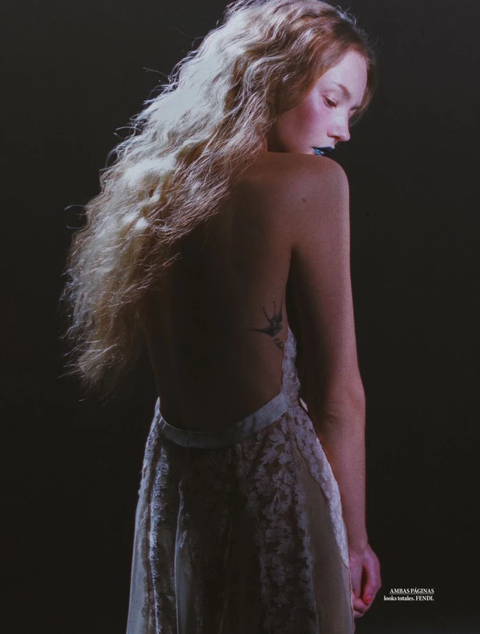 Model Katya Plotnikova in a backless lace gown against a dark background for Elle Mexico shot by Jesús Soto Fuentes