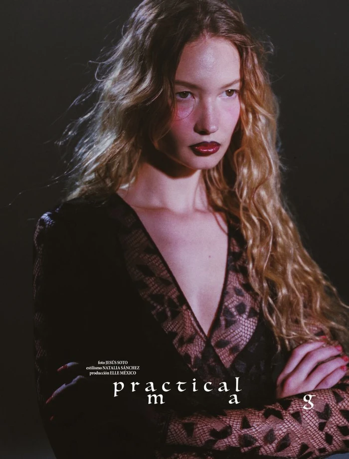 Model Katya Plotnikova in a black lace dress with long wavy hair against a dark background for Elle Mexico Practical Magic editorial.