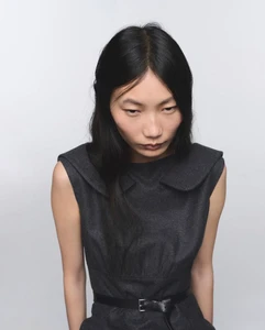 Model Ruyu Chen wearing a dark wool dress against a seamless white background for Prada Re-Cashmere and Re-Wool