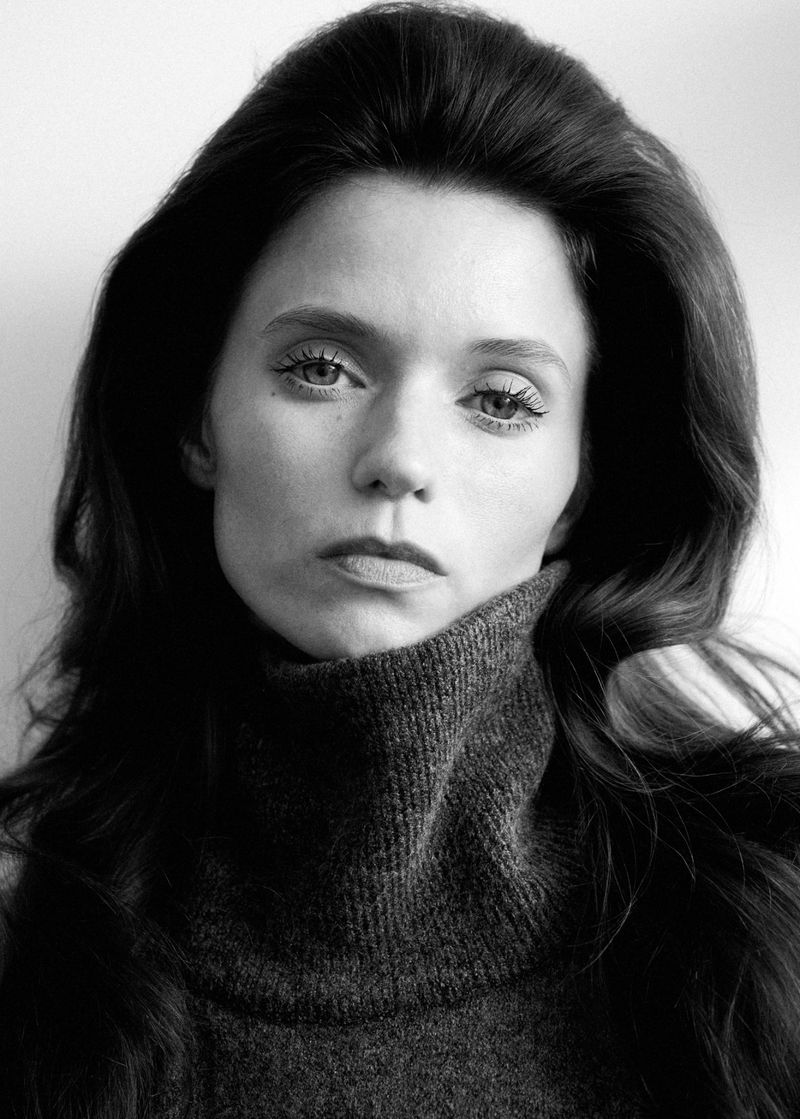 Portrait of Abbey Lee wearing a dark turtleneck sweater against a plain white background for Mango Fall 26