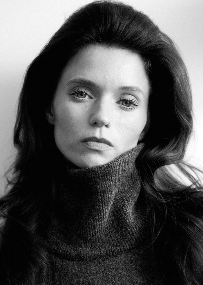 Portrait of Abbey Lee wearing a dark turtleneck sweater against a plain white background for Mango Fall 26