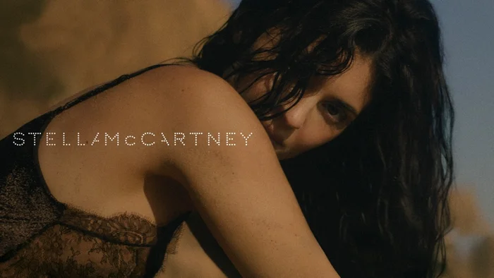 Kylie Jenner wearing a dark lace camisole outdoors at sunset for Stella McCartney