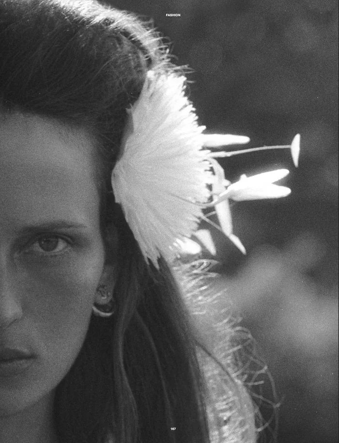 Close-up monochrome portrait of model Waleska Gorczevski wearing a large white flower in her hair for Numero Netherlands.