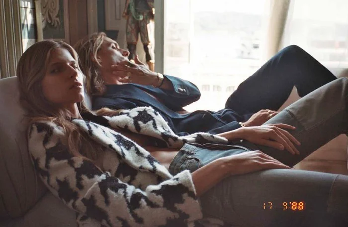 Two models relaxing on a sofa in an interior setting, shot for Numéro Istanbul editorial by Emre Dogru