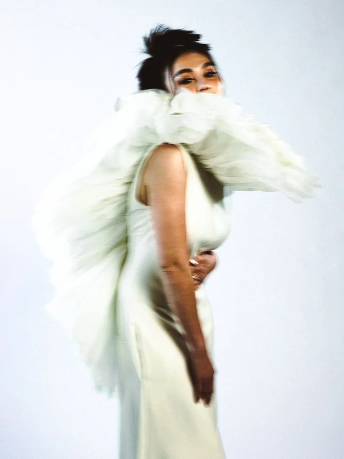 Portrait of Agnez Mo wearing a sculptural white ruffled dress with motion blur against a white background for Schon Magazine
