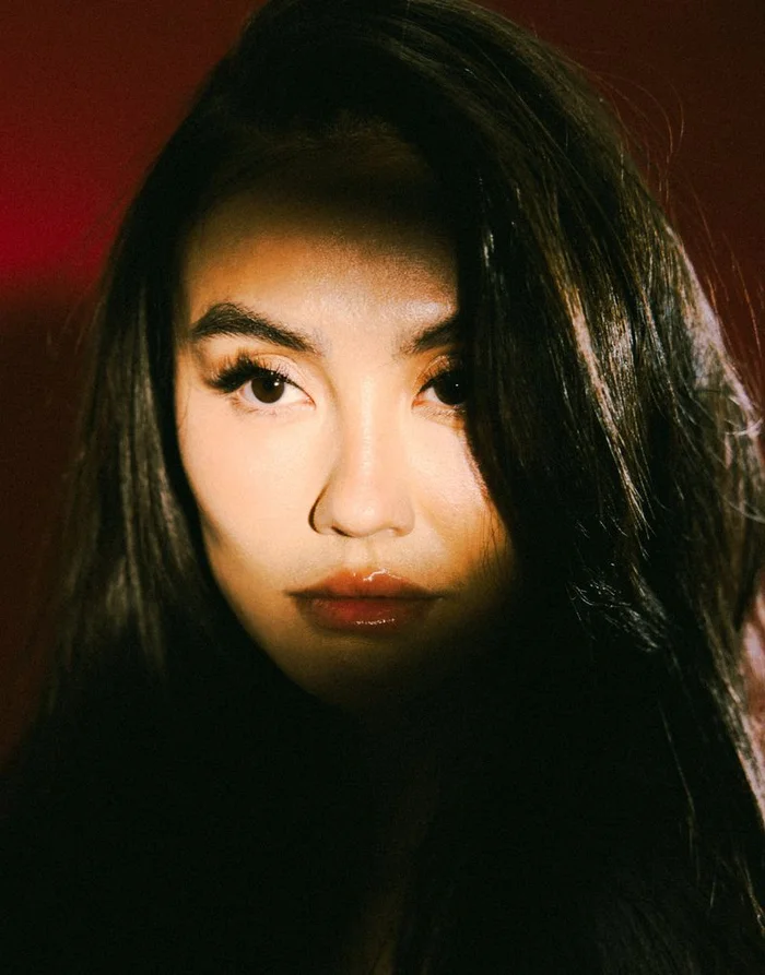 Close-up portrait of Agnez Mo with dark hair and striking lighting casting shadows across her face for Schon Magazine.