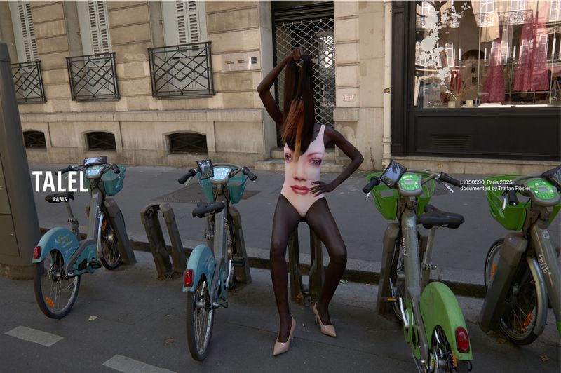 Woman in face-print bodysuit strikes a pose among bikes on a Paris street; European architecture and 'Talel Paris' visible in the background.