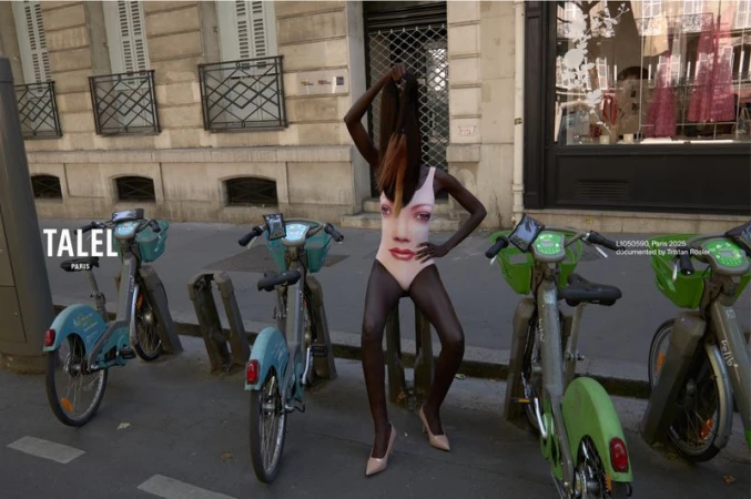 Woman in face-print bodysuit strikes a pose among bikes on a Paris street; European architecture and 'Talel Paris' visible in the background.