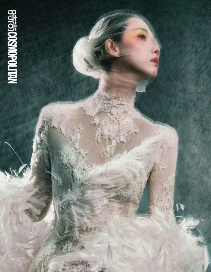 Chen Duling wearing a white lace dress with feather trims and sheer veil in an editorial for Cosmopolitan China by Songze Tu