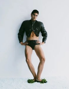 Male model in a cropped black jacket and black briefs posing against a white background for GQ Portugal