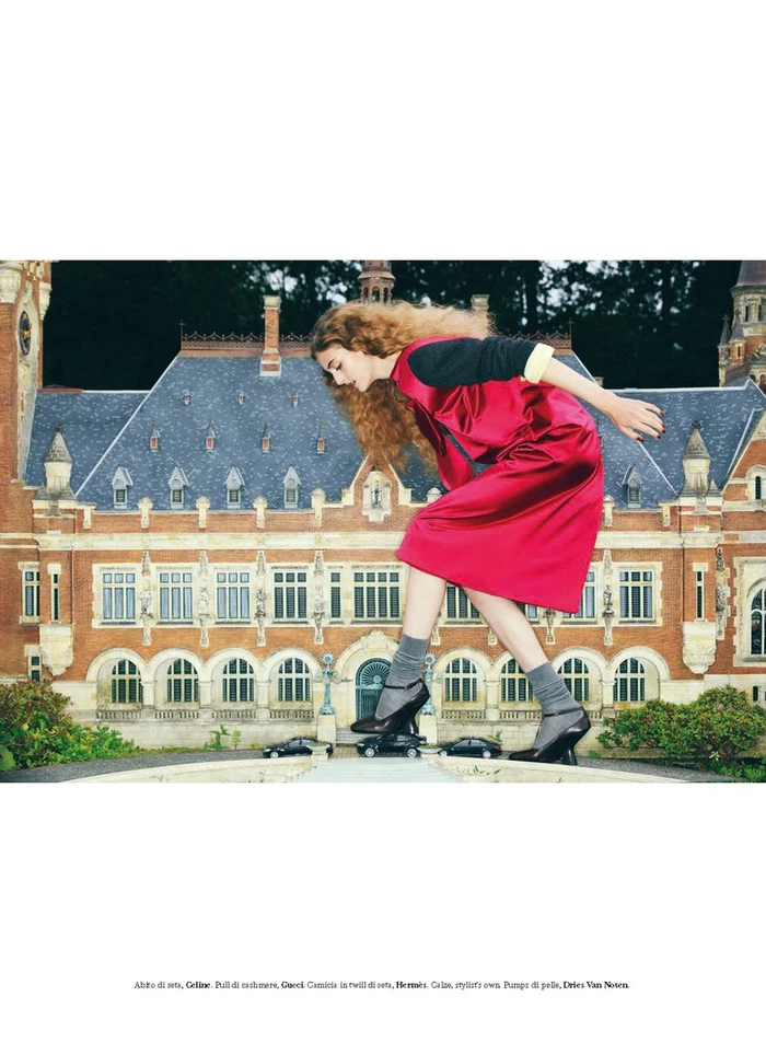 Frauke Nijs modeling a red dress and dark shoes with miniature cars against a building model for D Repubblica