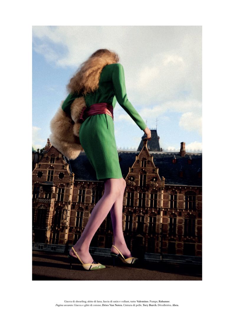 Model Frauke Nijs in a green dress and pink tights walking against an architectural backdrop by Carlijn Jacobs