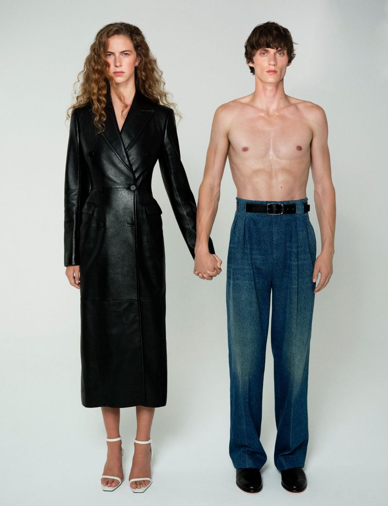 Two models standing against a neutral studio backdrop, holding hands in a fashion portrait for Numero China.