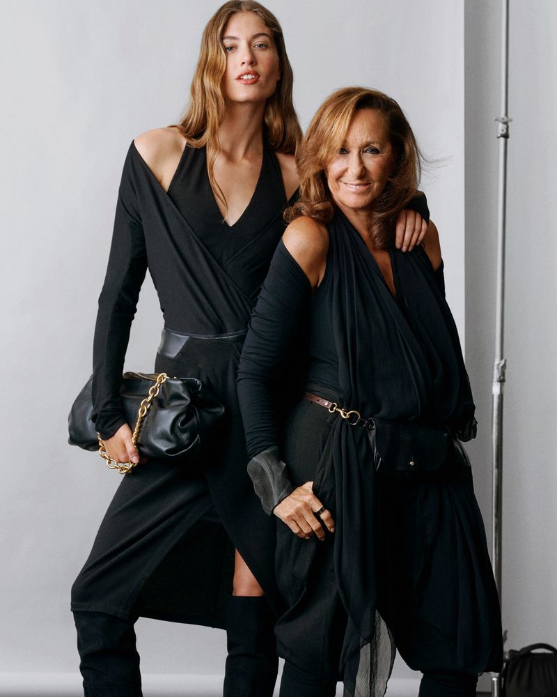 Two women wearing black dresses standing against a neutral studio backdrop, photographed by Scott Trindle for Macy's.