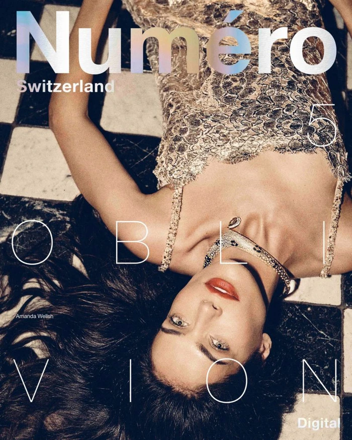 Model Amanda Wellsh lying on a black and white tiled floor wearing a textured dress and jeweled choker for Numéro Switzerland