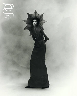 Model wearing a dark starburst headpiece and gown in a black and white fashion editorial for Hia Magazine.