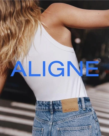 Fashion shot featuring a model wearing light blue jeans and a white tank top, showcasing the brand's Aligne logo on the clothing.