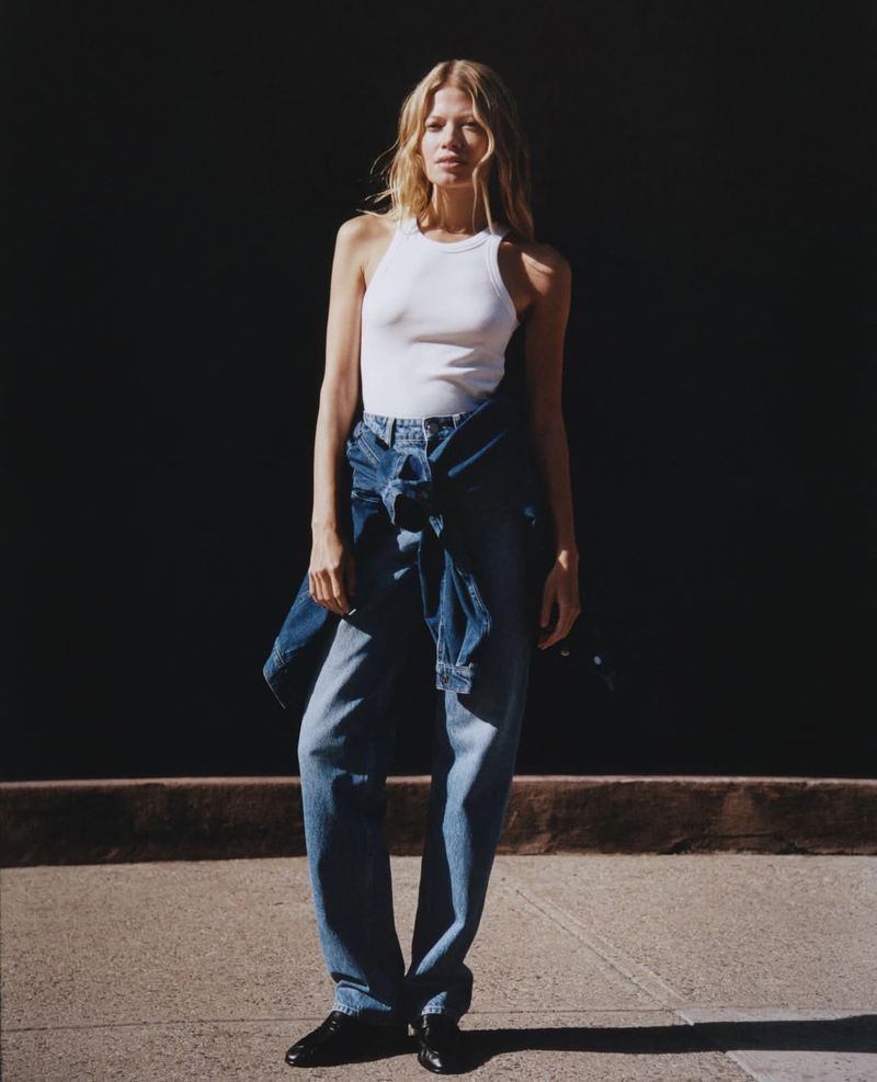 Model Schirin Frosch wearing a white tank top and blue denim jeans for the ALIGNE Denim Campaign 2025 shot by Ivan Bideac
