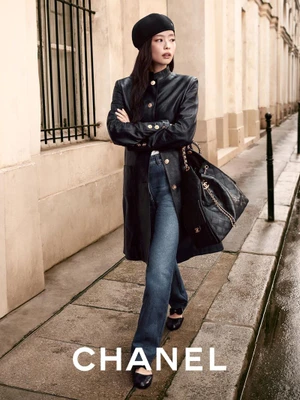 Jennie wearing a black leather jacket and beret walking on a street for Chanel Fall Winter 2025/26 Pre-Collection