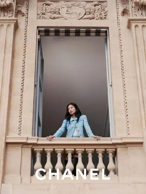 Jennie leaning on a stone balcony in a light blue jacket for Chanel Fall Winter 2025/26 Pre-Collection
