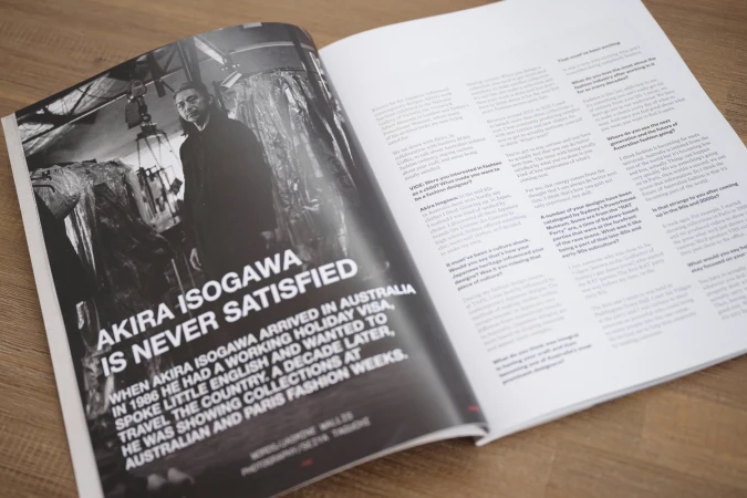 Black and white magazine spread features a portrait of Akira Isogawa, overlaid with bold text highlighting his name and career beginnings.