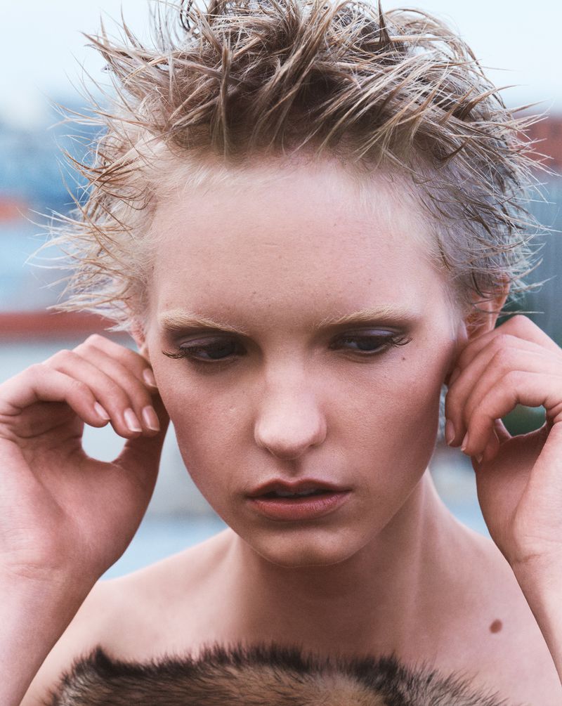 Close-up portrait of model Gretchen Easterwood with spiky wet blonde hair holding her ears for Re-Edition Magazine