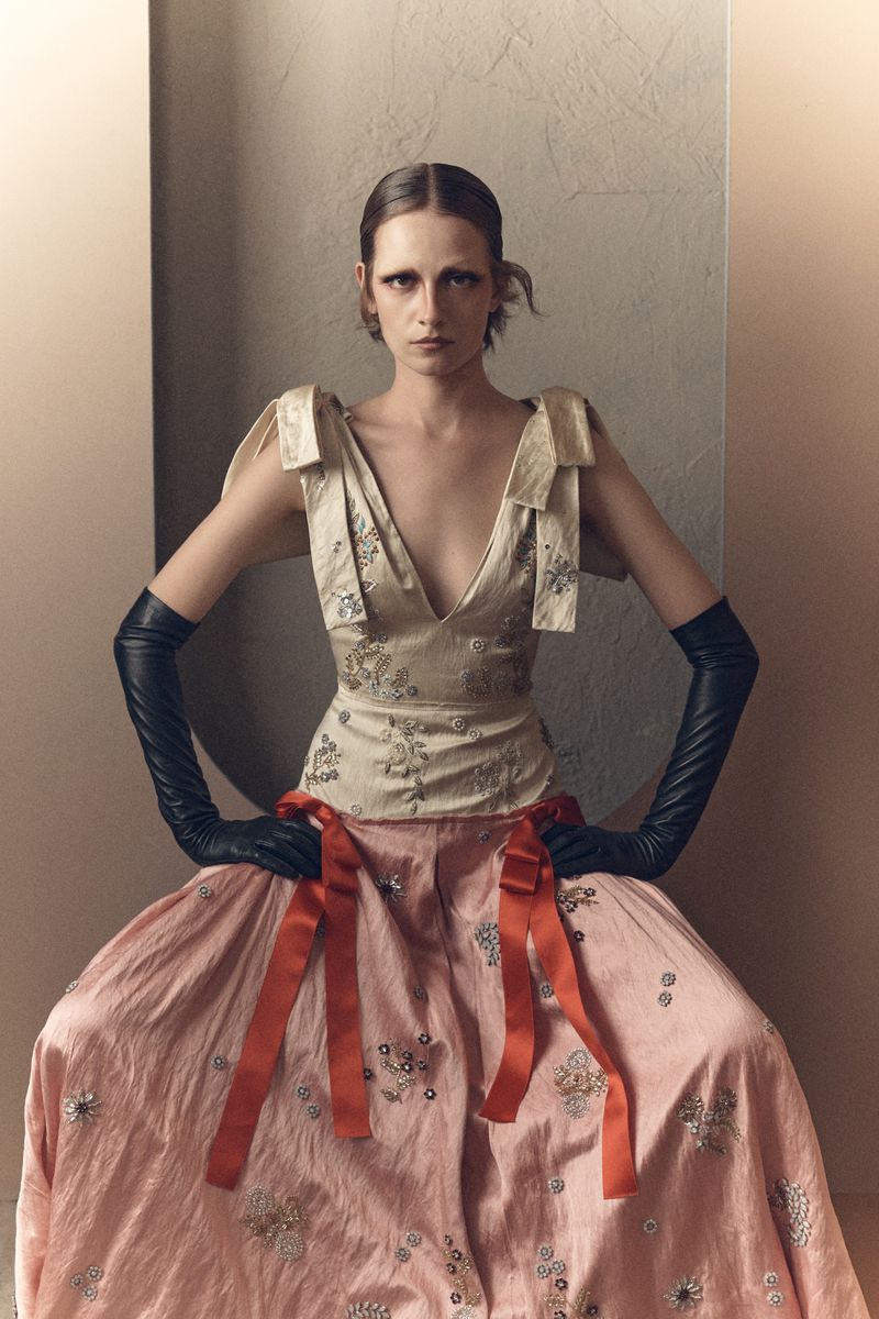Model Sophie Dominique Gonzalez in an embellished top and pink skirt with black leather gloves for Vogue Greece