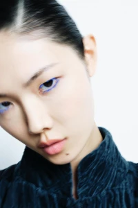 Close-up portrait of model Sijia Kang with vibrant blue eyeliner against a plain white background for Zara.