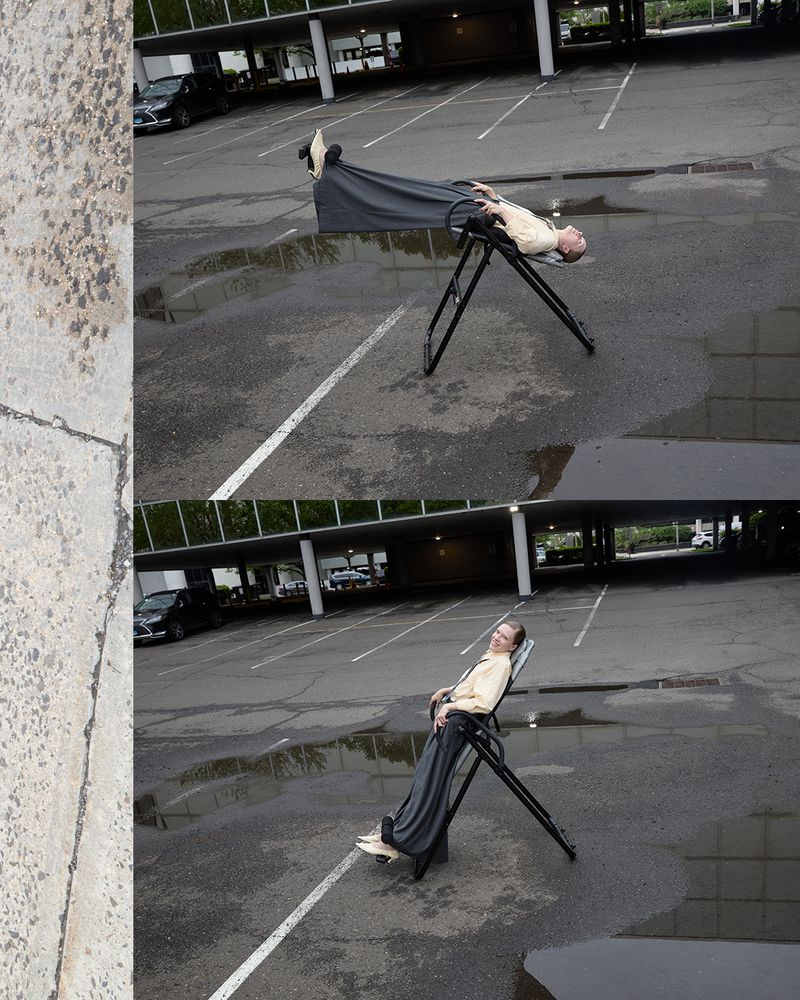 Man rests on an inversion table in a parking lot with puddles, showcasing a humorous juxtaposition of leisure and an urban environment.