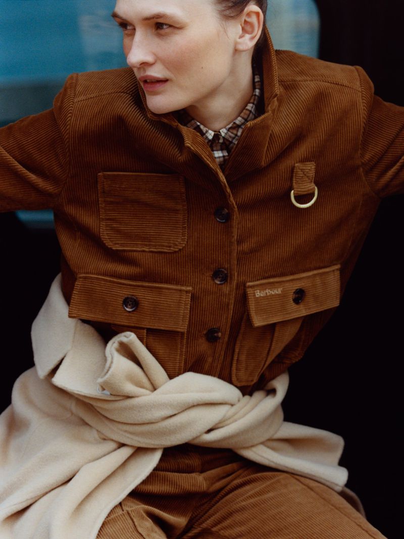 Model Lara Mullen wearing a brown corduroy jacket for Vogue Greece urban armor editorial photographed by Magnus Lechner.