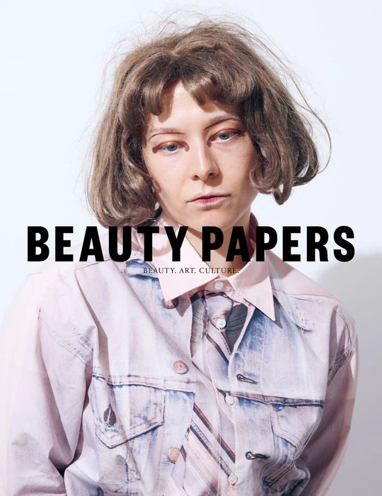 Portrait of Emma D'Arcy wearing a printed shirt against a plain white background for Beauty Papers.
