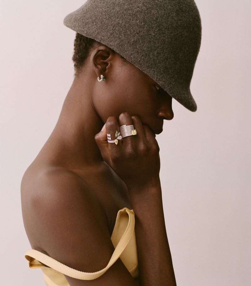 Model Agel Akol wearing diamond rings and a felt hat for Heroine Magazine