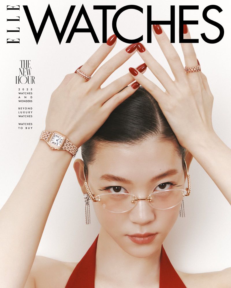 Close-up fashion shot of an Asian woman wearing earrings, rings, a dress, and a watch, with her hands raised above her head.
