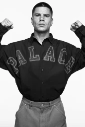 Man wearing a black button-down shirt with embossed PALACE branding posing against a plain background