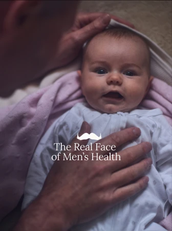 An adult cradling a baby wrapped in a blanket, with text overlay from Movember campaign