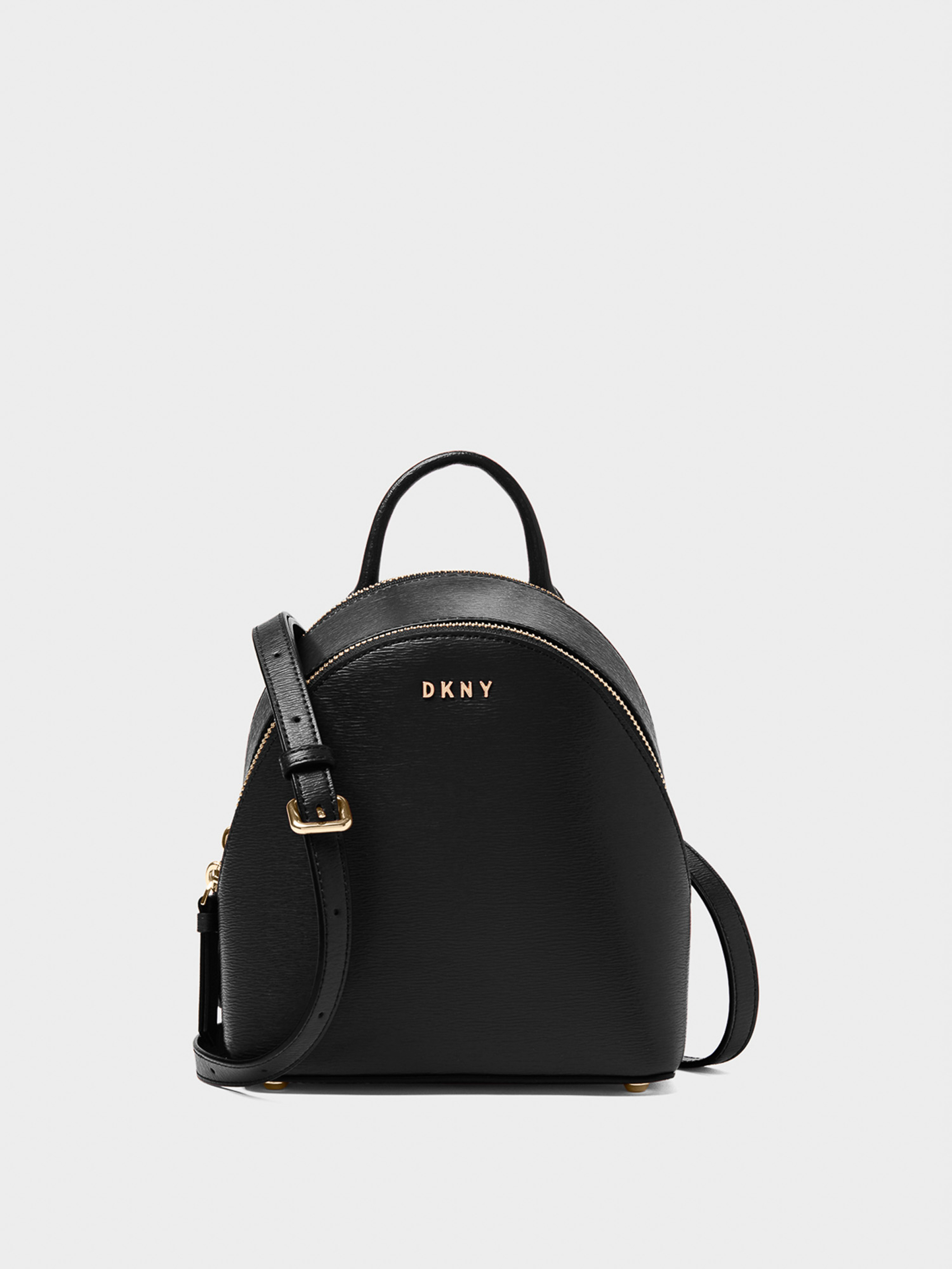 Black DKNY mini backpack with gold accents, featuring a top handle, adjustable shoulder straps, and a pebbled leather texture. Studio lit.