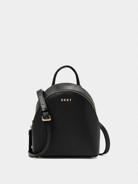 Black DKNY mini backpack with gold accents, featuring a top handle, adjustable shoulder straps, and a pebbled leather texture. Studio lit.