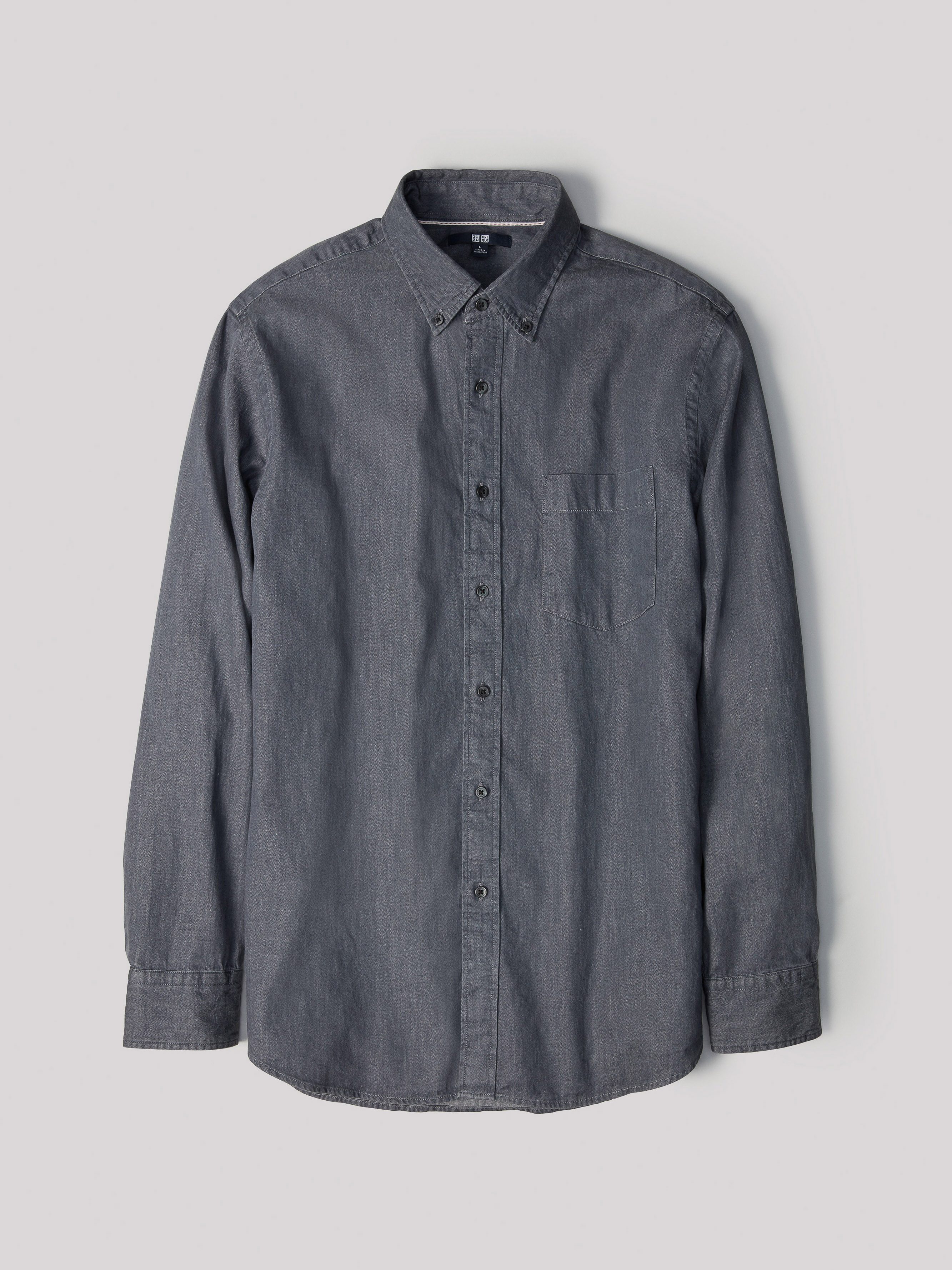 Uniqlo dark grey long-sleeve button-down shirt displayed flat against a plain light grey backdrop.