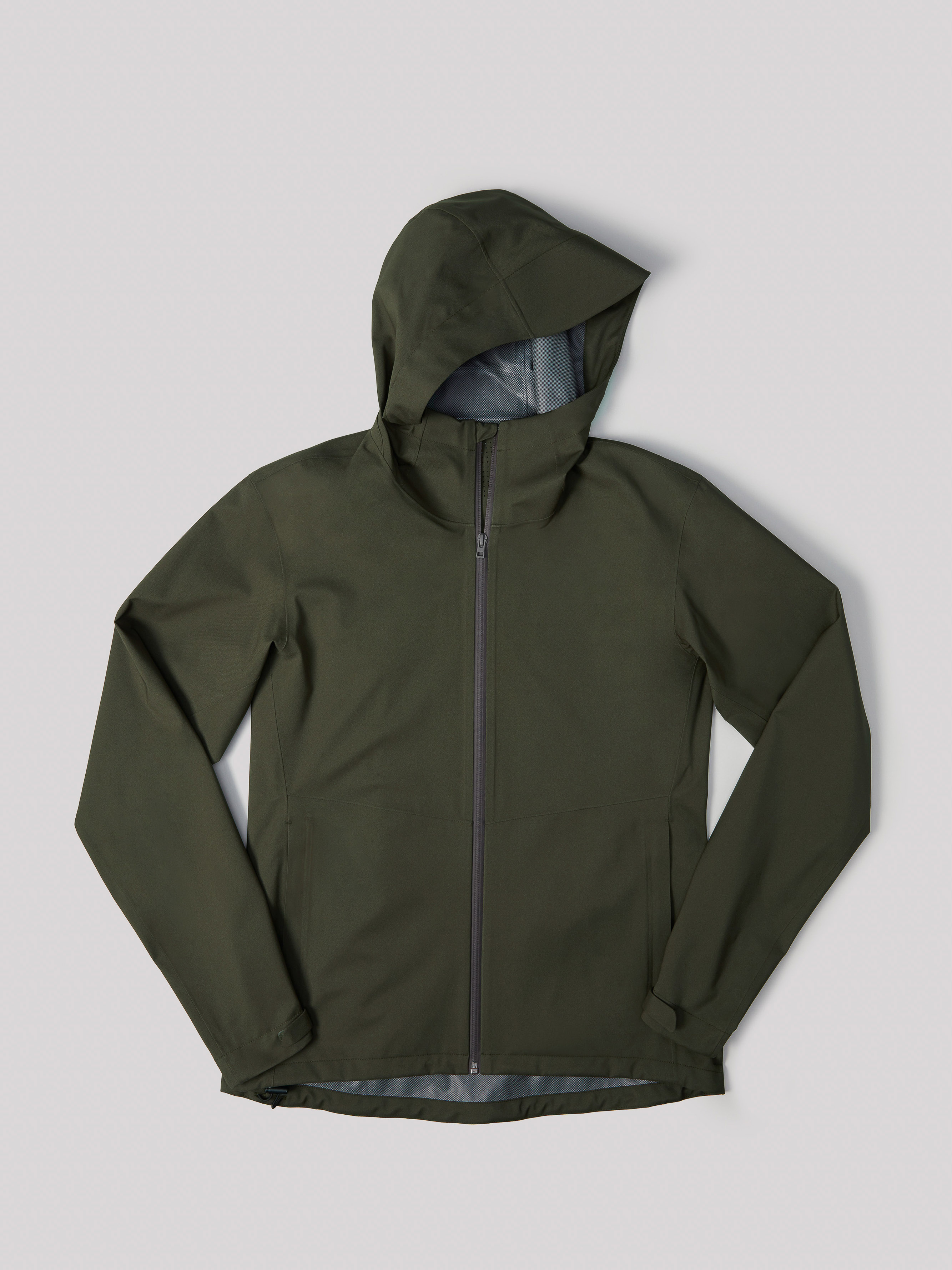 Olive green hooded rain jacket with a zippered front, presented on a light gray background in a studio setting. Fashion apparel.