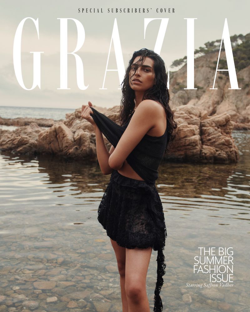 Grazia magazine cover featuring a woman standing in water with rocks and greenery in the background, wearing a black top and skirt.