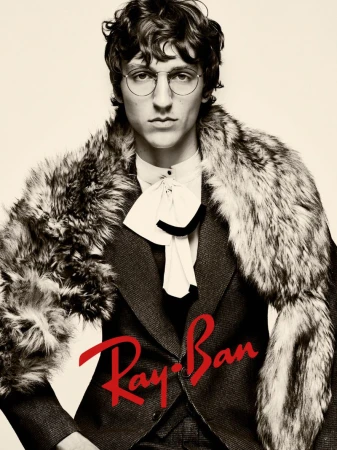 Portrait of a man wearing a tweed suit, a white ruffled shirt, round glasses, and a fur stole, with the Ray-Ban logo.
