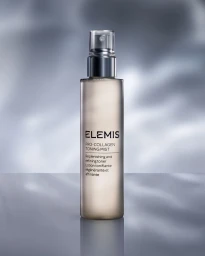 Elemis Pro-Collagen Toning Mist bottle centered upright on a reflective grey surface with a mottled grey background.