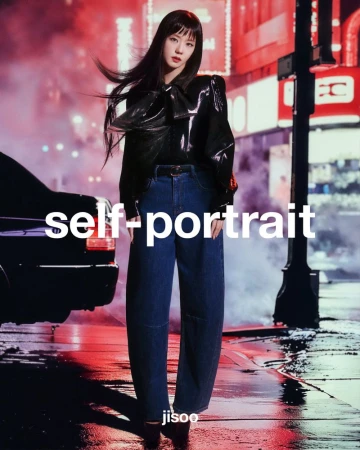 Korean woman, Jisoo, poses in wide-legged jeans and shiny black blouse on a city street at night with neon lights reflecting.