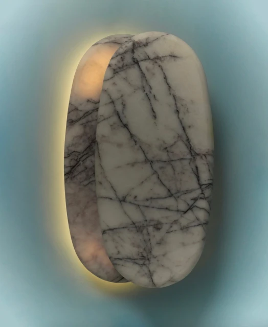 Illuminated white marble wall sconces with black veining against a light blue wall, emitting a warm ambient light, interior lighting.