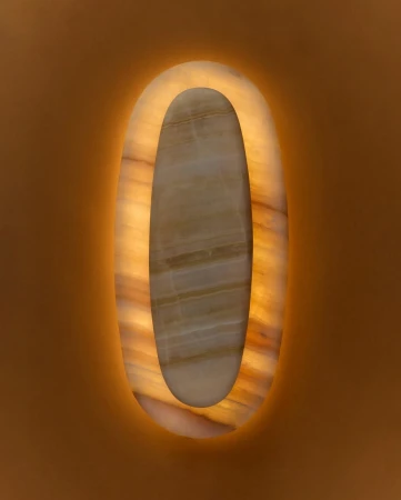 Abstract illuminated wall decor with a central marble section and a border of glowing warm light, casting soft light against the plain wall.