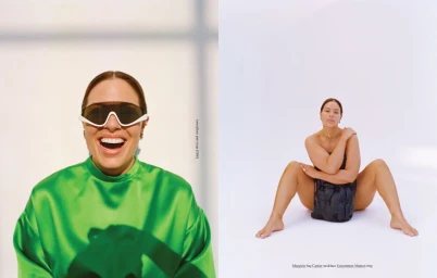 Ashley Graham in a vibrant green satin top wearing white futuristic sunglasses against a plain white background