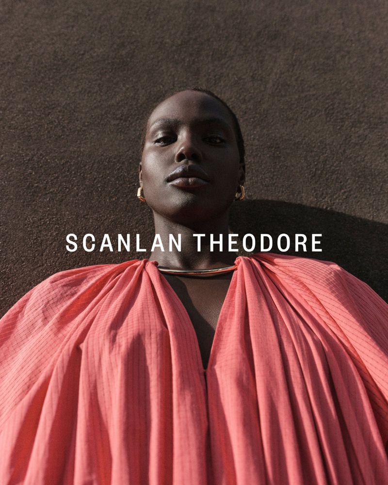 Portrait of a Black woman in a pink dress with gold jewelry, against a textured brown background, featuring the text SCANLAN THEODORE.