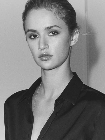 Black and white portrait of Quinn Mora wearing an unbuttoned black collared shirt for Massimo Dutti.