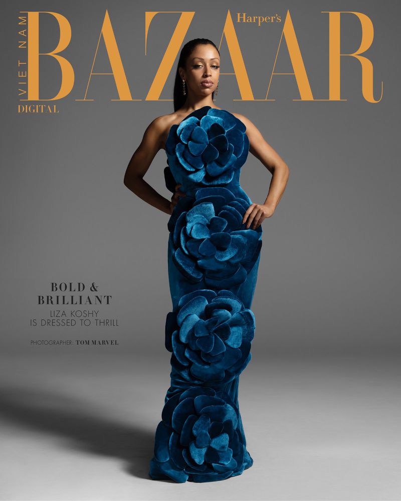 Liza Koshy on the cover of Harper's Bazaar Vietnam Digital, wearing a blue velvet gown adorned with flower appliques against gray backdrop.