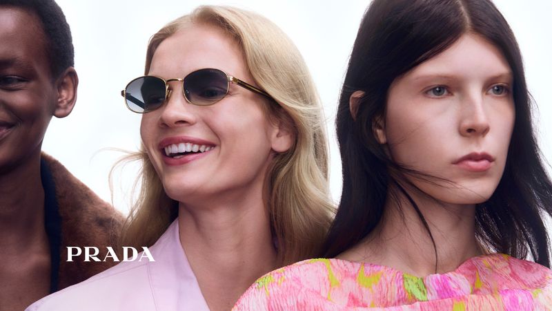 Close-up of three fashion models: an African American woman smiling, a blonde woman with sunglasses, and a fair-skinned woman.